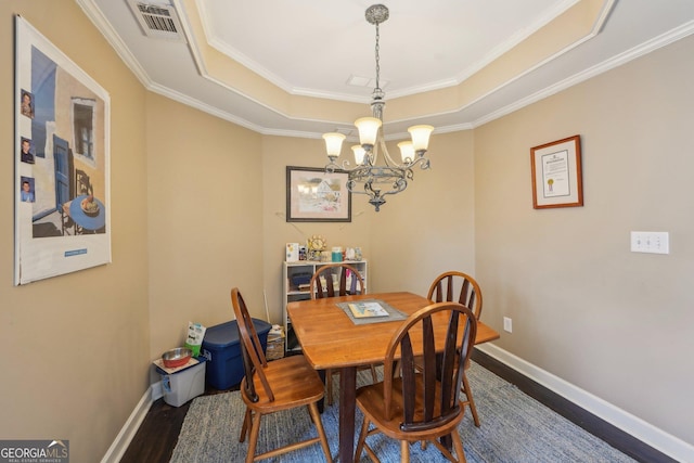 4740 Arbor Meadows Dr, Cumming, GA 30040 - dining room with wood finished floors, visible vents, baseboards, a tray ceiling, and an inviting chandelier