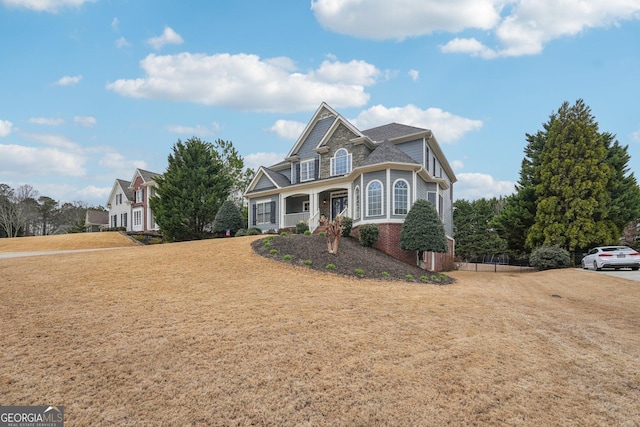 view of front facade with brick siding and a front lawn