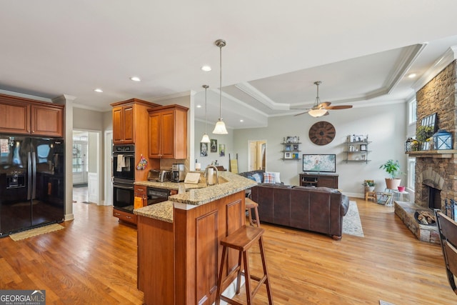 4740 Arbor Meadows Dr, Cumming, GA 30040 - kitchen with a fireplace, black appliances, light stone countertops, a peninsula, and a kitchen breakfast bar