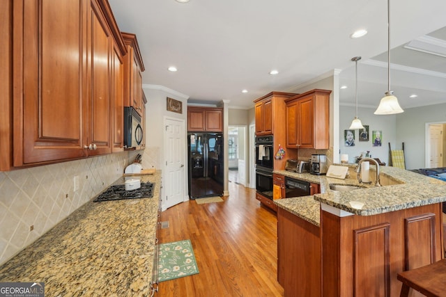 4740 Arbor Meadows Dr, Cumming, GA 30040 - kitchen featuring light stone counters, a sink, light wood-type flooring, a peninsula, and black appliances