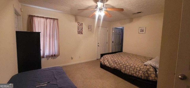 carpeted bedroom with visible vents, ceiling fan, a textured ceiling, and baseboards