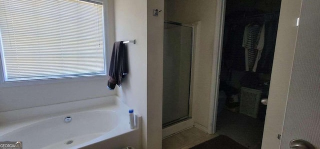 bathroom featuring a shower stall and a bath