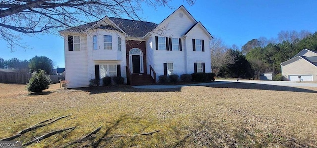 split foyer home featuring a front lawn and fence