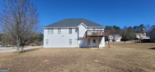 rear view of property with a deck and a yard