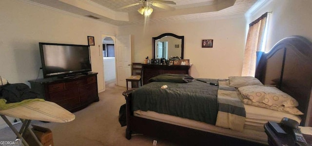 carpeted bedroom with arched walkways, visible vents, a ceiling fan, ornamental molding, and a tray ceiling