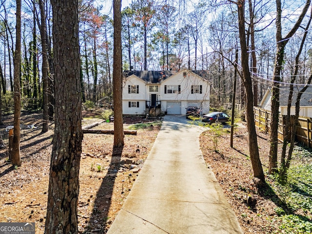 view of front of property featuring driveway and fence