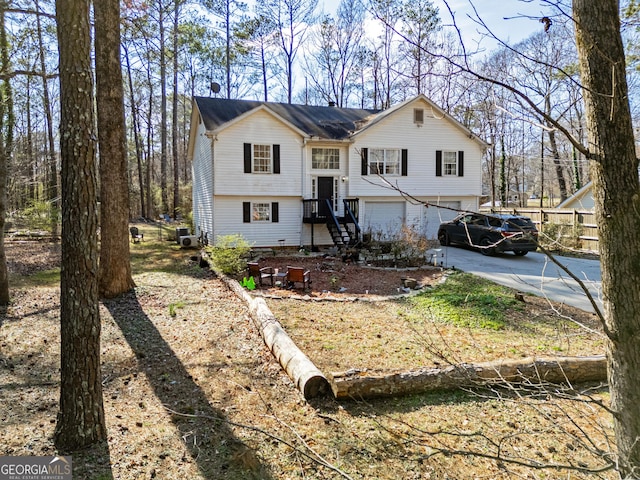 raised ranch featuring an attached garage and concrete driveway