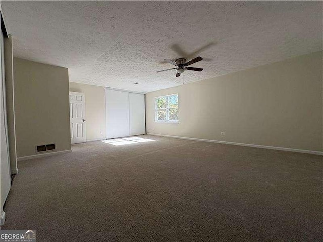 carpeted spare room with a ceiling fan, baseboards, visible vents, and a textured ceiling