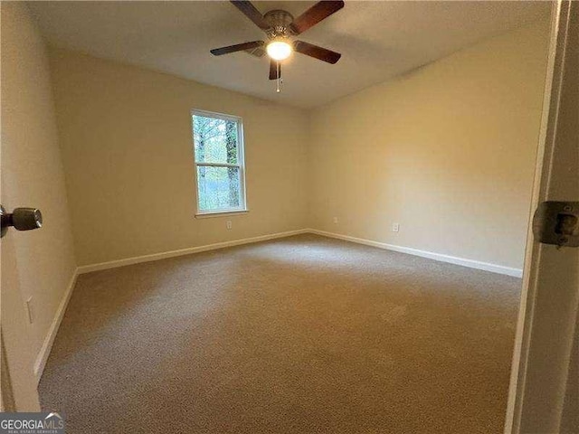 carpeted empty room featuring ceiling fan and baseboards