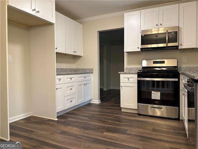 kitchen featuring light stone counters, dark wood finished floors, stainless steel appliances, ornamental molding, and white cabinets