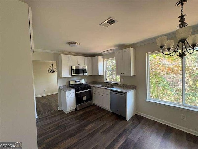 kitchen with stainless steel appliances, a sink, visible vents, white cabinets, and crown molding