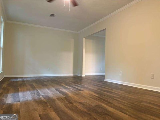 unfurnished room featuring baseboards, visible vents, dark wood-type flooring, and ornamental molding