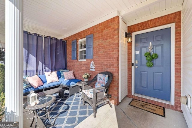 entrance to property with covered porch and brick siding