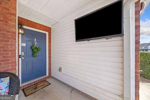 property entrance featuring brick siding