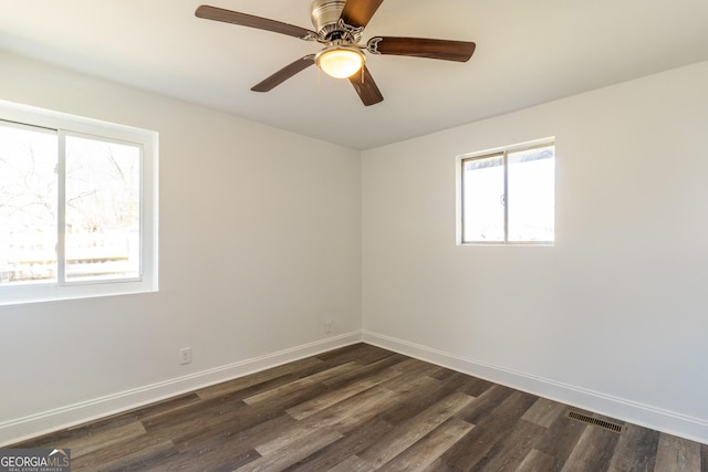 unfurnished room featuring baseboards, visible vents, ceiling fan, and dark wood-style flooring