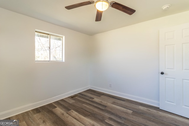 spare room with dark wood-style floors, baseboards, and a ceiling fan