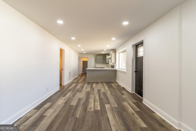 interior space featuring recessed lighting, dark wood finished floors, and baseboards