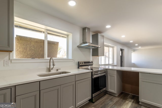 kitchen with a sink, wall chimney range hood, gray cabinetry, and stainless steel electric stove