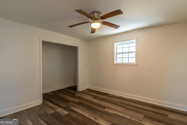 unfurnished bedroom featuring a ceiling fan, baseboards, and dark wood-type flooring