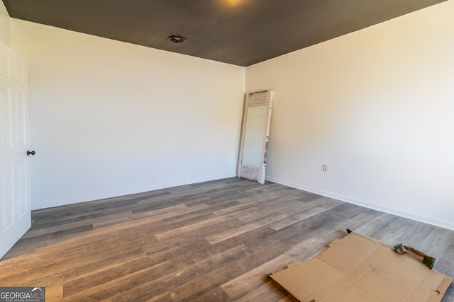 empty room with baseboards and wood finished floors