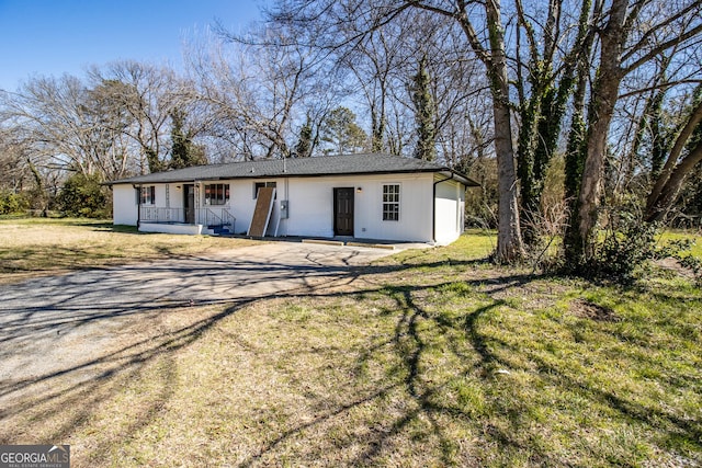 view of front of home with covered porch and a front lawn