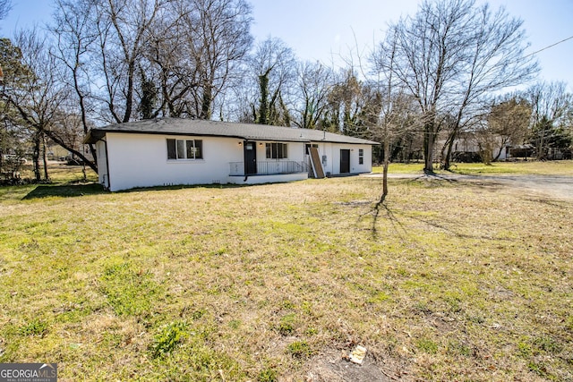 ranch-style home with covered porch and a front yard