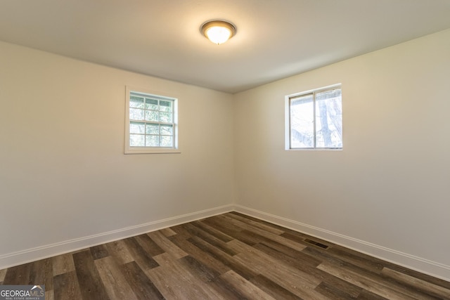 empty room featuring a healthy amount of sunlight, visible vents, and baseboards