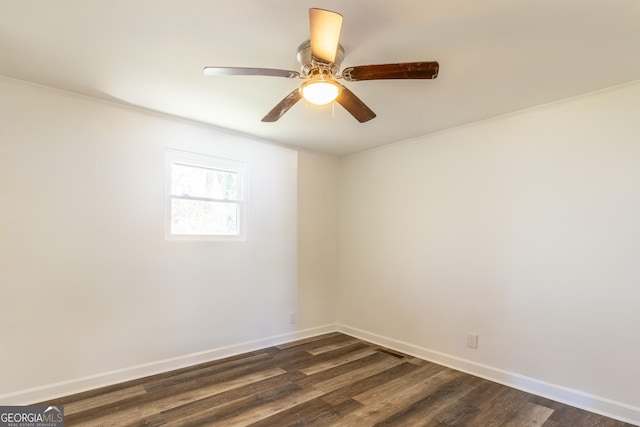 empty room with ceiling fan, dark wood-style flooring, and baseboards