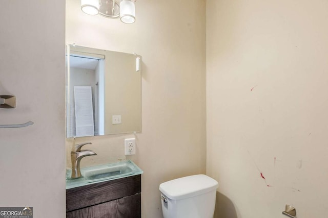 bathroom featuring a chandelier, vanity, and toilet