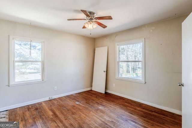 unfurnished room featuring ceiling fan, plenty of natural light, wood finished floors, and baseboards