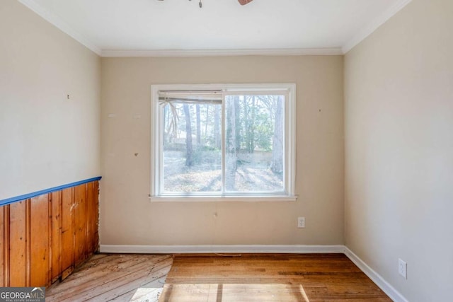 unfurnished room with ornamental molding, baseboards, and hardwood / wood-style floors