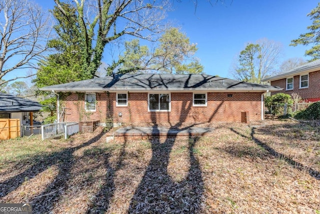 rear view of property featuring a patio area, brick siding, and fence