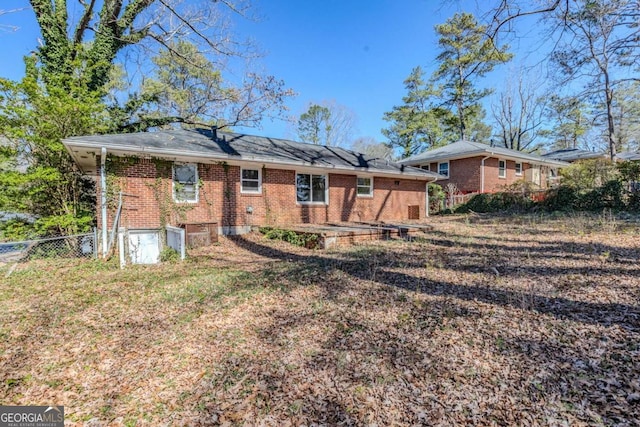 back of property featuring brick siding and fence