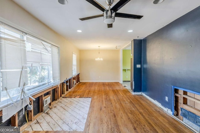 interior space with recessed lighting, baseboards, wood finished floors, and ceiling fan with notable chandelier