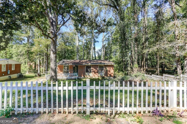 view of front of house featuring covered porch, a fenced front yard, and brick siding