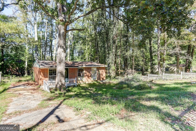 view of yard featuring covered porch and fence