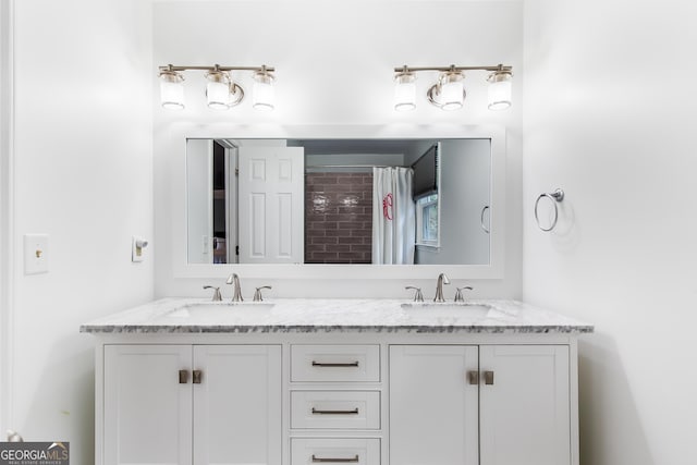 bathroom featuring a shower with curtain, a sink, and double vanity