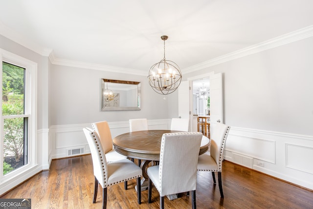 dining room with an inviting chandelier, visible vents, wood finished floors, and a wainscoted wall