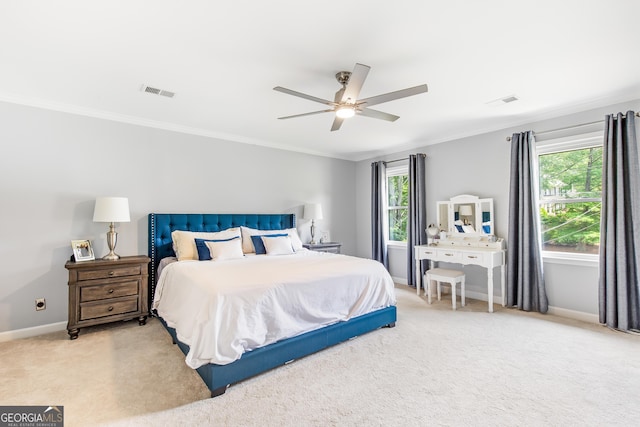 carpeted bedroom featuring baseboards, visible vents, ceiling fan, and ornamental molding