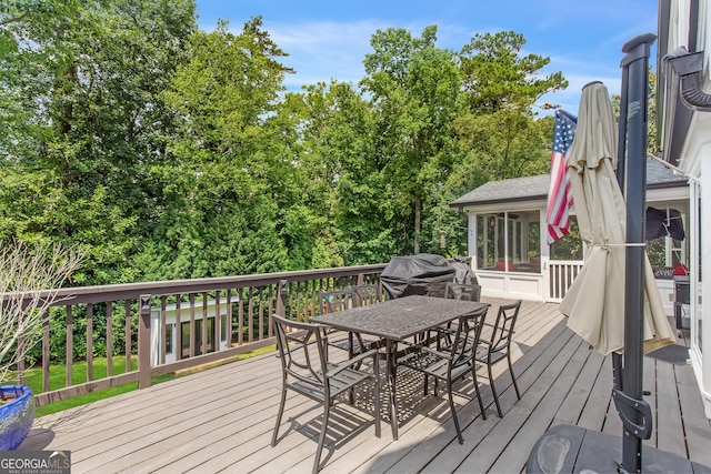 wooden deck with outdoor dining area and a sunroom