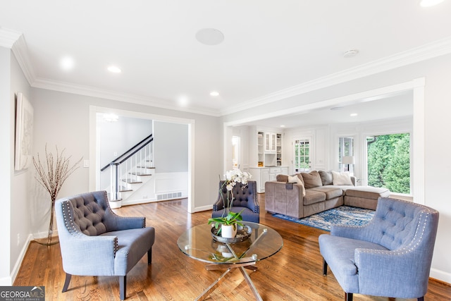 living room featuring ornamental molding, wood finished floors, and visible vents