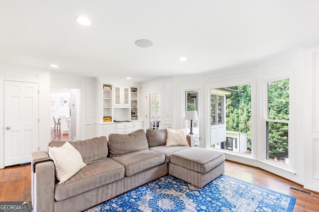 living area featuring recessed lighting, visible vents, and wood finished floors