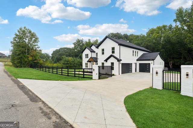 view of front of house with driveway, a fenced front yard, a front yard, and a gate