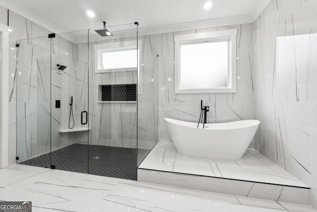 bathroom with a freestanding tub, a marble finish shower, and tile walls