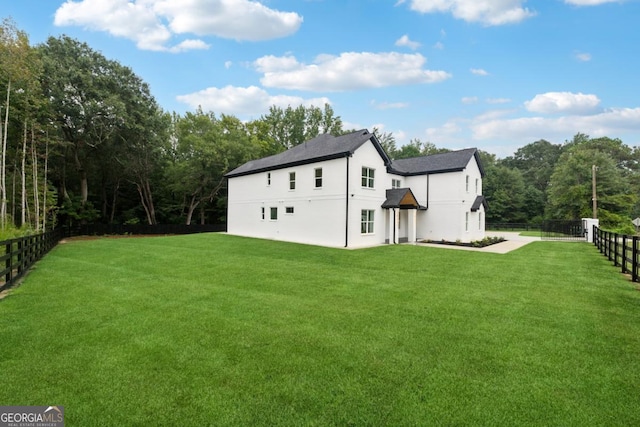 rear view of property featuring a fenced backyard and a lawn