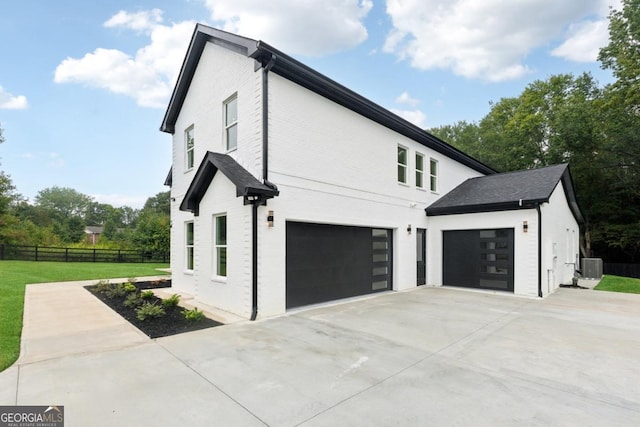 view of home's exterior featuring a garage, central AC unit, a lawn, concrete driveway, and fence