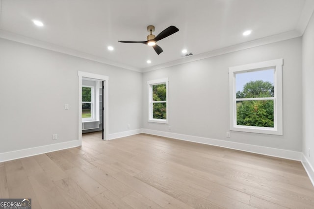 spare room featuring ceiling fan, ornamental molding, light wood-style flooring, and baseboards