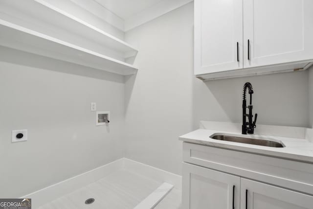 laundry room featuring hookup for a washing machine, a sink, cabinet space, and hookup for an electric dryer