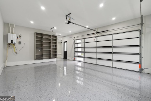 garage featuring baseboards, tankless water heater, and a garage door opener