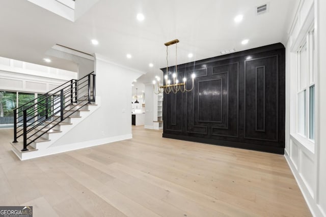 interior space featuring light wood finished floors, recessed lighting, visible vents, ornamental molding, and stairs